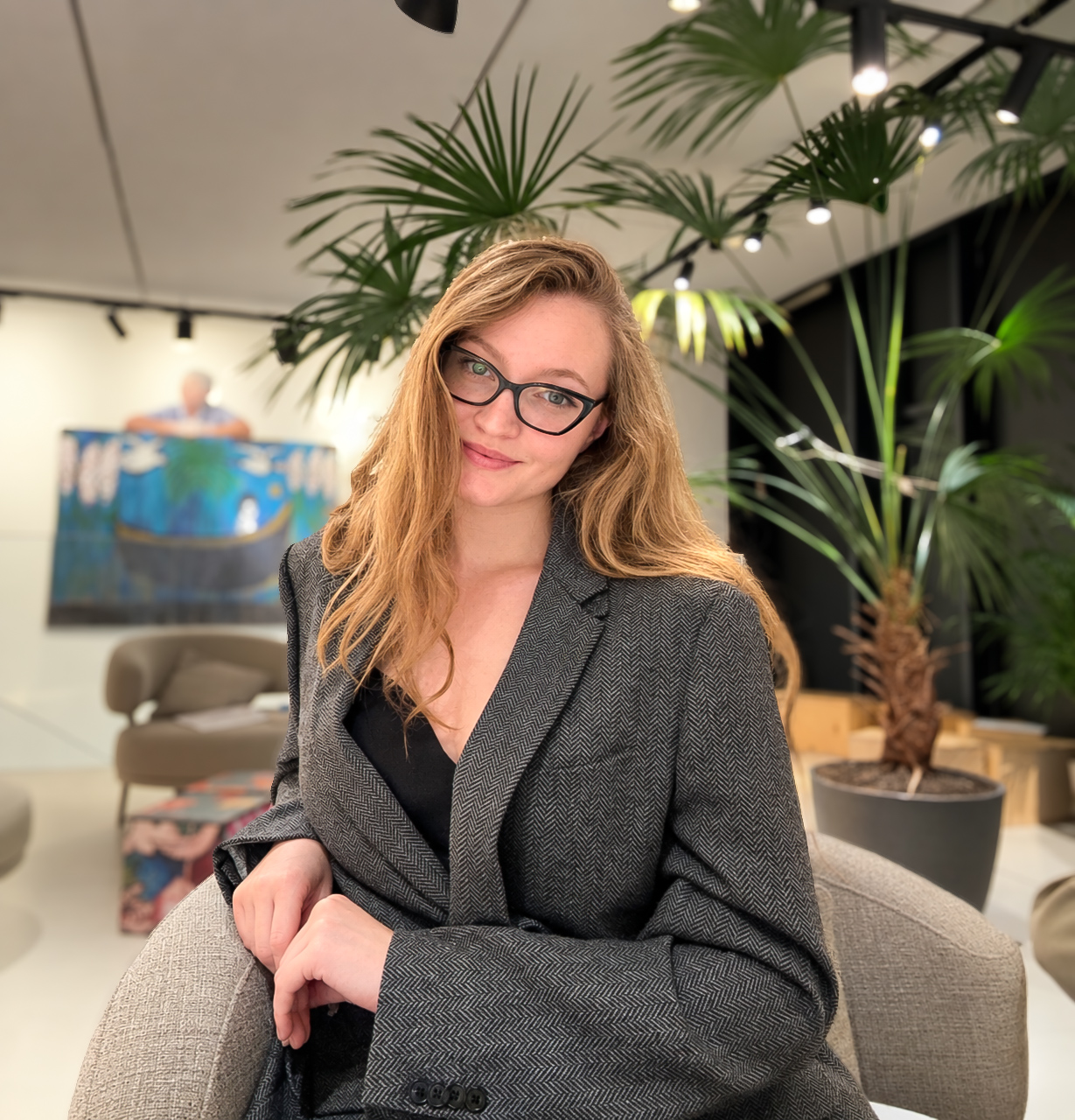 Alina seated in a grey blazer